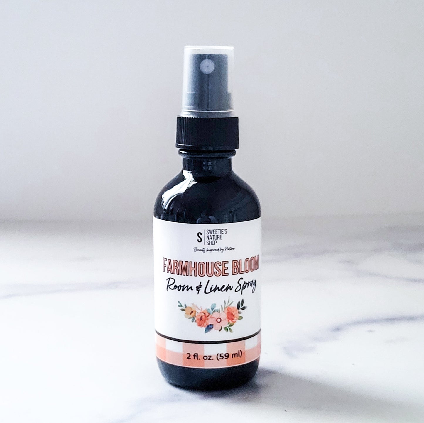 Room and linen spray bottle labeled 'Farmhouse Bloom' on a white background