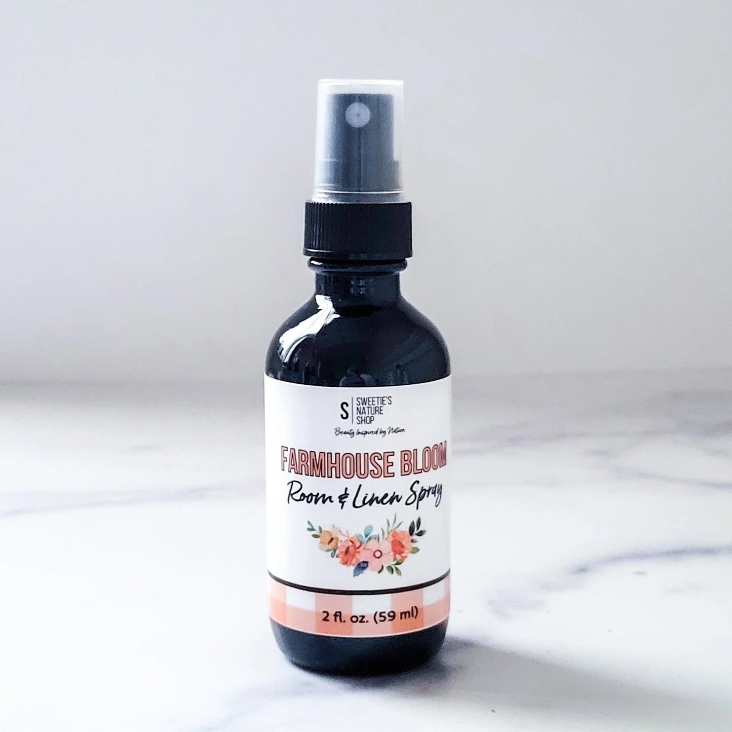 Room and linen spray bottle labeled 'Farmhouse Bloom' on a white background