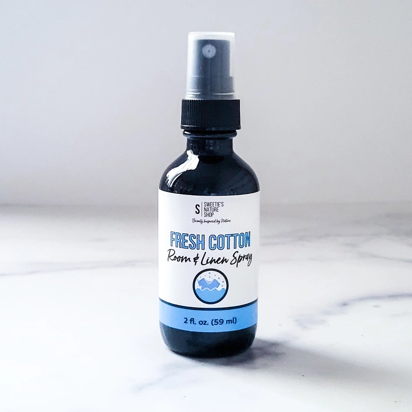 Bottle of fresh cotton room and linen spray on a marble surface