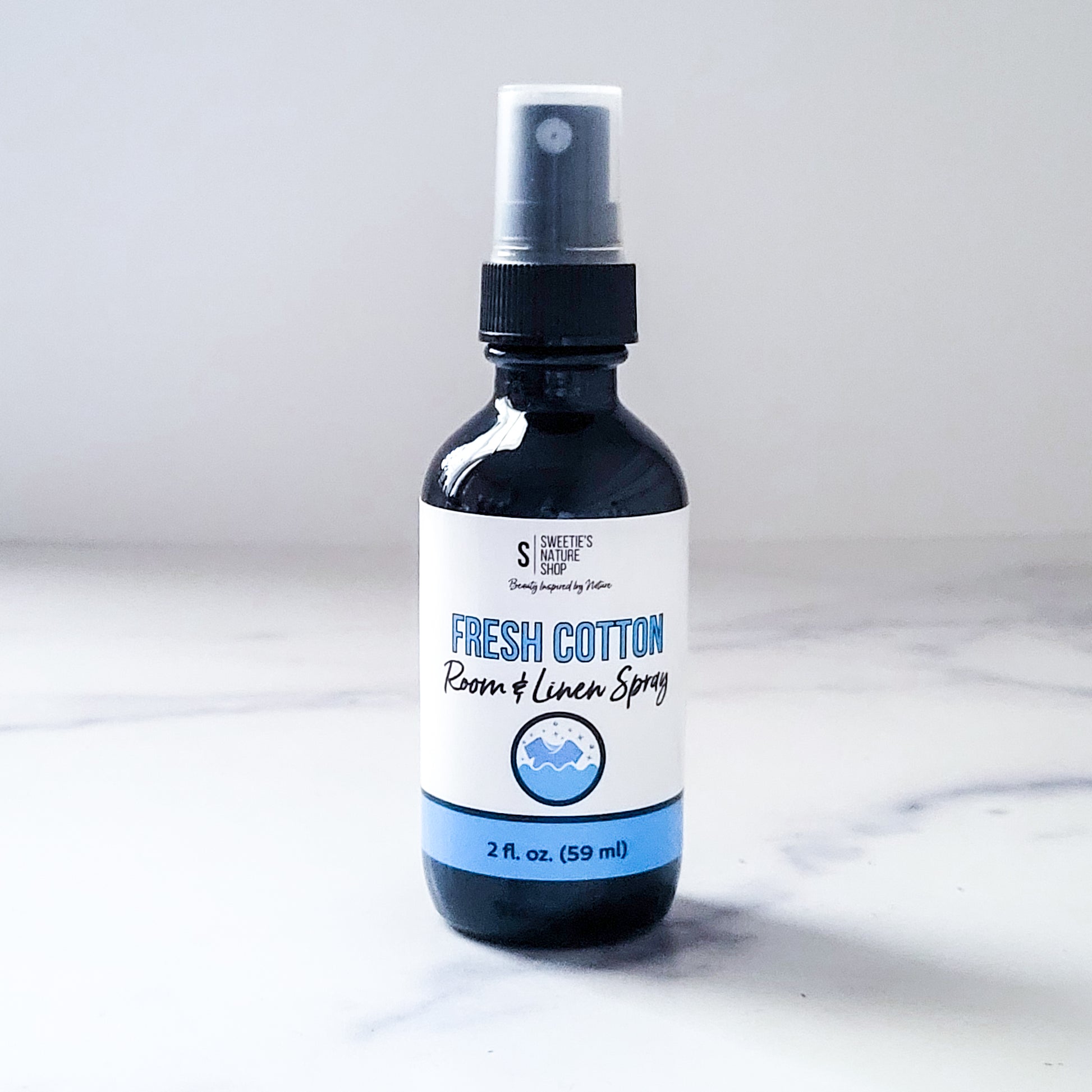 Bottle of fresh cotton room and linen spray on a marble surface