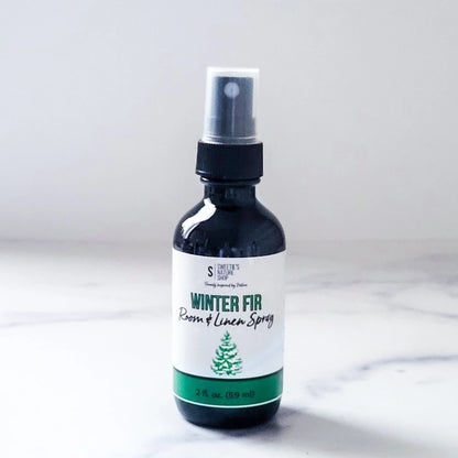 Bottle of 'Winter Fir' room and linen spray on a white background